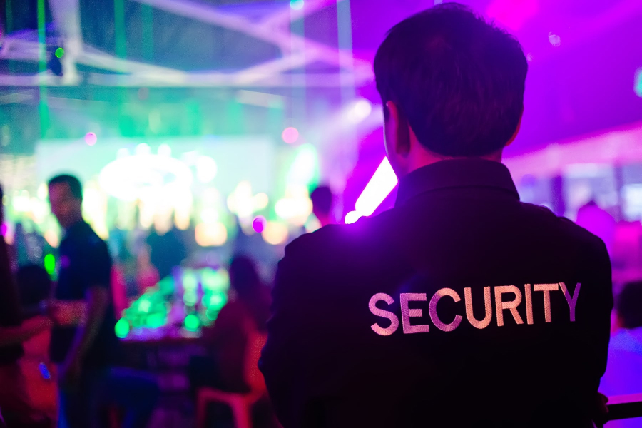 Security officer watching a nightclub floor under stage lighting